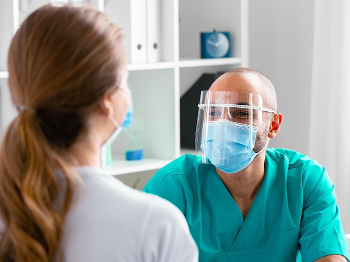 Medic cu mască Covid examinează pacientul